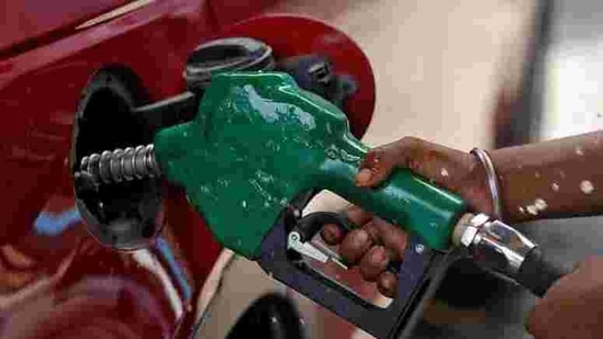 A worker holds a nozzle to pump petrol into a vehicle at a fuel station in Mumbai.(Reuters File Photo)