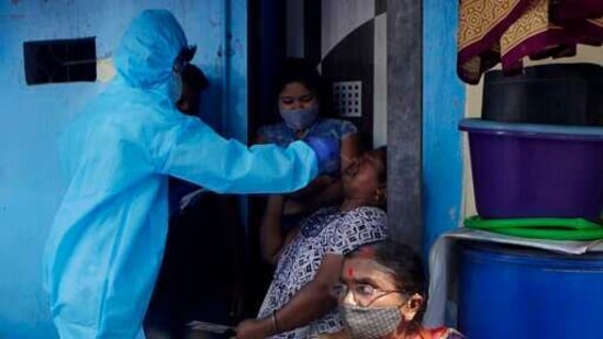 A health worker collects swab samples during door-to-door screening for Covid-19 people at Dharavi in Mumbai on Friday.(AP Photo ) A health worker collects swab samples during door-to-door screening for Covid-19 people at Dharavi in Mumbai on Friday.(AP Photo )
