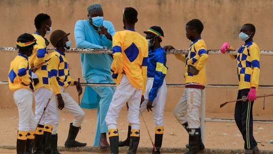 Adama Bao, a coach who owns the Lambafar stable, speaks to Fallou Diop and other jockeys before a race at the Hippodrome Ndiaw Macodou DIOP in Thies, Senegal on January 31. "[Diop] is very gifted and has a lot of skill," Bao told Reuters. "He could compete up to 50 years with his weight and size." (Zohra Bensemra / REUTERS)
