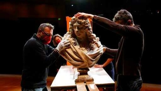 Workers handle a bust of Charles Le Brun by French sculptor Antoine Coysevox, in the Louvre museum, in Paris, Wednesday, Feb. 17, 2021. It's uncertain when the Louvre will reopen, after being closed on Oct. 30 in line with the French government's virus containment measures. But those lucky enough to get in benefit from a rarified private look of collections covering 9,000 years of human history -- with plenty of space to breathe. (AP Photo/Thibault Camus)(AP)