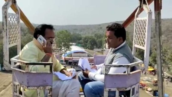 Madhya Pradesh's Minister of State for Public Health Engineering (PHE) Brijendra Yadav speaks on his phone from a giant wheel 50 feet above the ground in Surel village of Ashok Nagar district. (HT PHOTO) Madhya Pradesh's Minister of State for Public Health Engineering (PHE) Brijendra Yadav speaks on his phone from a giant wheel 50 feet above the ground in Surel village of Ashok Nagar district. (HT PHOTO)