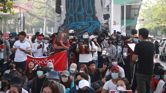 Protesters gather in front of three-fingered salute graffiti during an anti-coup protest in Sanchaung township, outskirt of Yangon, Myanmar on February 21, 2021. (AP) Protesters gather in front of three-fingered salute graffiti during an anti-coup protest in Sanchaung township, outskirt of Yangon, Myanmar on February 21, 2021. (AP)