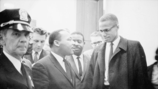 Martin Luther King Jr. and Malcolm X (R) wait for a press conference to begin in an unknown location, March 26, 1964 in this file photo. (AFP)