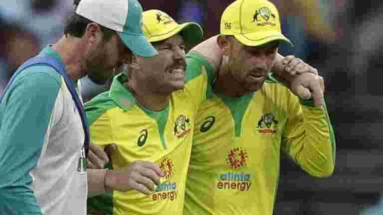 Australia's David Warner, centre, is assisted from the field after injuring himself while fielding during the one day international cricket match between India and Australia at the Sydney Cricket Ground in Sydney, (AP) Australia's David Warner, centre, is assisted from the field after injuring himself while fielding during the one day international cricket match between India and Australia at the Sydney Cricket Ground in Sydney, (AP)
