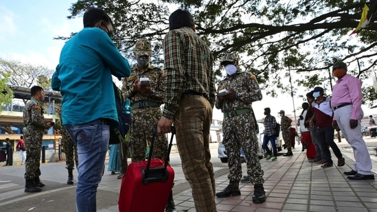 Officials levy fine on commuters who failed to wear face masks outside a bus station in Bengaluru.(AP) Officials levy fine on commuters who failed to wear face masks outside a bus station in Bengaluru.(AP)
