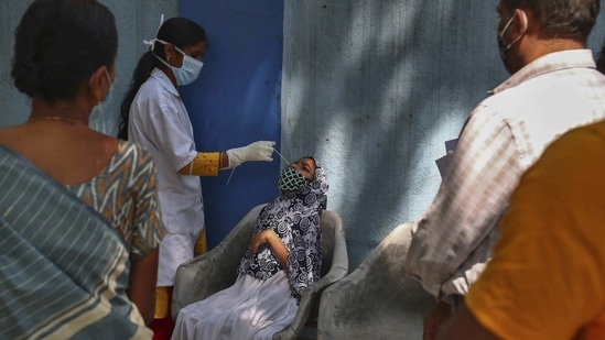 A health worker takes a nasal swab sample at a Covd-19 testing center in Hyderabad.(AP) A health worker takes a nasal swab sample at a Covd-19 testing center in Hyderabad.(AP)