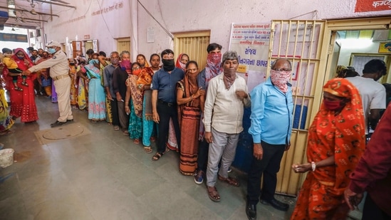 Voters stand in a queue to cast their vote at a polling centre during Gujarat Municipal Elections, in Ahmedabad, Sunday.