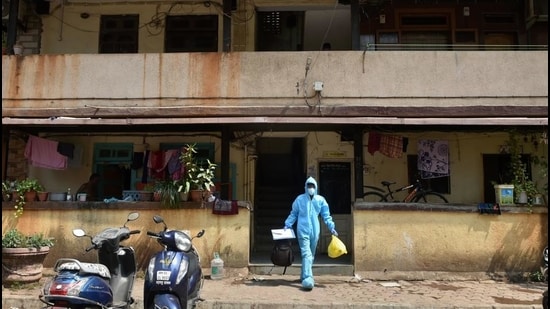A health worker leaves a residential area after conducting swab tests for Covid-19 following the rise in Coronavirus disease cases at Dharavi, in Mumbai. (PTI)