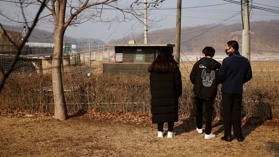 A North Korean defector and his children stand in front of a barbed wire fence near the demilitarised zone separating the two Koreas, in Paju,(Reuters)
