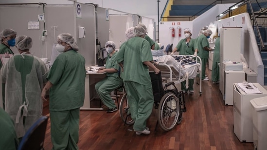Healthcare workers treat Covid-19 patients inside a field hospital at the Pedro Dell'Antonia sports complex in Santo Andre, Brazil. (Bloomberg) Healthcare workers treat Covid-19 patients inside a field hospital at the Pedro Dell'Antonia sports complex in Santo Andre, Brazil. (Bloomberg)