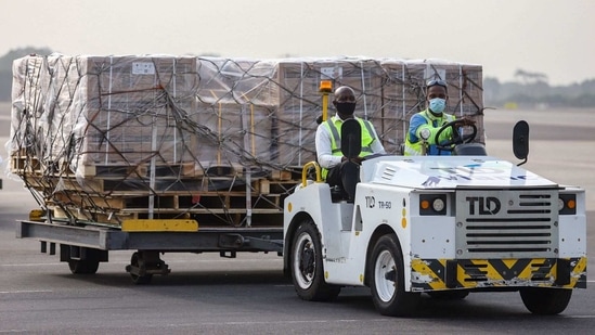 Airport workers transport on dollies a shipment of Covid-19 vaccines from the Covax global Covid-19 vaccination programme, at the Kotoka International Airport in Accra.(AFP)