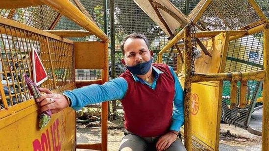 With his arm instinctively holding onto the wheeled metal barrier, ready to slide as soon as another car appears, Subodh explains his arrival from his countryside home to this smoggy metropolis. With his arm instinctively holding onto the wheeled metal barrier, ready to slide as soon as another car appears, Subodh explains his arrival from his countryside home to this smoggy metropolis.