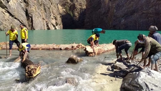 An SDRF team widening the channel of a glacial lake in Uttarakhand to increase the discharge of water from it on Wednesday.(SDRF)