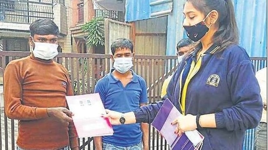 School students distribute home-made face masks among people from the weaker sections of society. 