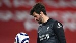 Liverpool's goalkeeper Alisson looks down at the ball during the English Premier League soccer match between Liverpool and Everton at Anfield in Liverpool.(AP)