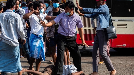 A military supporter points a sharp object as he confronts anti-coup protesters during a military support rally in Yangon, Myanmar on February 25. Junta supporters wielding knives and slingshots clashed with residents in Myanmar's largest city on February 25, as tensions rise after weeks of nationwide protests against the military coup.(REUTERS)