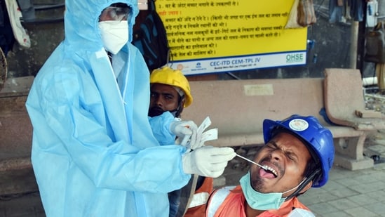 A healthcare worker collects swab sample of a Metro worker for the COVID-19 test in Mumbai.(ANI File Photo)