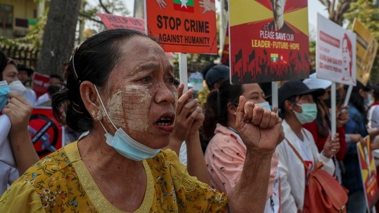 Anti-coup protesters shout slogans during a street march in Mandalay on February 25. Security forces eventually arrived at the site of clashes to find women and children linking arms in front of the railway compound to prevent them from arresting any anti-coup protesters, AFP reported.(AP)