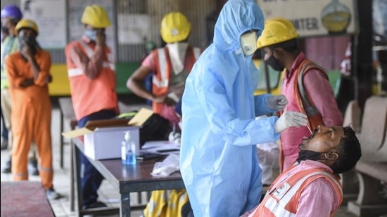 A BMC health worker collects swab sample of a construction worker for Covid-19 test, at Siddhivinayak Metro site in Mumbai on February 25. (PTI)