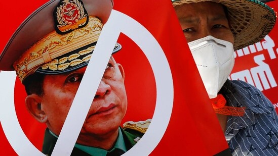 A protester holds a placard with a zero symbol over the face of Commander in chief, Senior Gen. Min Aung Hlaing during an anti-coup rally.(AP)