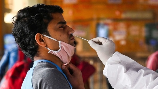 A medical worker takes a swab sample from a passenger for a Rapid Antigen Test (RAT) Covid-19 coronavirus test at the railway station in New Delhi.