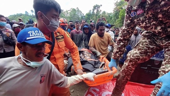 Rescue teams carry the body of a miner after an illegal gold mine collapsed killing at least three people, with more believed to be buried under the rubble, in the village of Buranga in Parigi Moutong Regency, Central Sulawesi on February 25, 2021. (Photo by RIDWAN / AFP)(AFP)