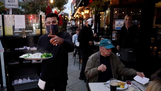 A server carries food for a customer at Ye Olde King's Head in Santa Monica, California. (AP) A server carries food for a customer at Ye Olde King's Head in Santa Monica, California. (AP)