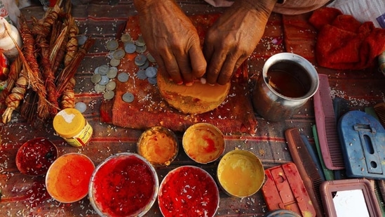A priest prepares vermillion paste for pilgrims at Sangam during Magh mela festival, in Prayagraj, India Friday, Feb. 19, 2021.(AP)
