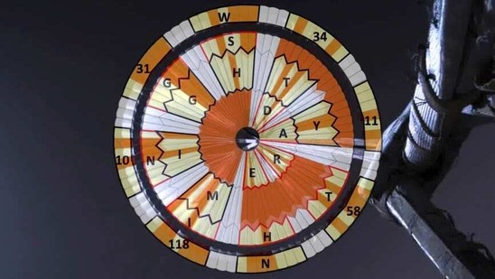 A diagram added over the parachute deployed during the descent of the Mars Perseverance rover as it approached the Martian surface on February 18. Systems engineer Ian Clark used a binary code to spell out “Dare Mighty Things” in the orange and white strips of the 70-foot (21-meter) parachute. He also included the GPS coordinates for the mission's headquarters at the Jet Propulsion Laboratory in Pasadena, California.(NASA / JPL-Caltech via AP)