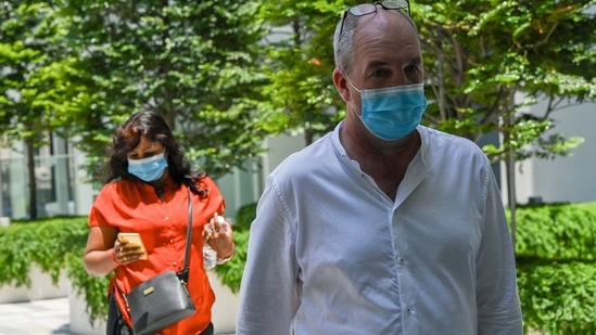 British national Nigel Skea (R) and wife Agatha Maghesh Eyamalai arrive at the State Court in Singapore on February 26, 2021.(AFP)