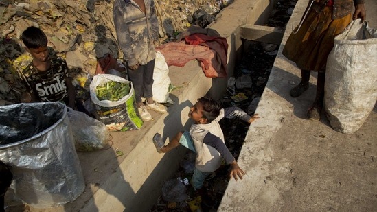 Imradul Ali, 10, center, plays as he looks for recyclable material at a landfill on the outskirts of Guwahati, India, Thursday, Feb. 4, 2021. (AP)