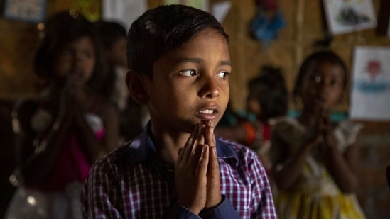 Imradul Ali, 10, prays with others in a classroom in a school near a landfill on the outskirts of Guwahati, India, Thursday, Feb. 4, 2021. (AP)