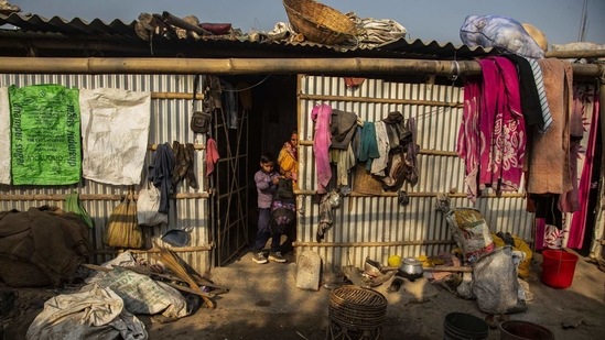 Imradul Ali, 10, center, takes his school bag from his mother Anuwara Beghum, 30, as he leaves for school from his rented room on the outskirts of Guwahati, India, Thursday, Feb. 4, 2021. (AP)