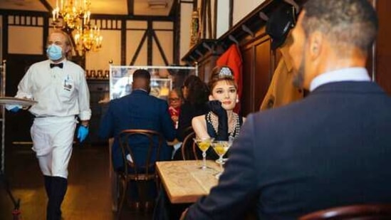 Wax statues of Audrey Hepburn and Michael Strahan occupy one of the tables at Peter Luger Steakhouse.(AP)