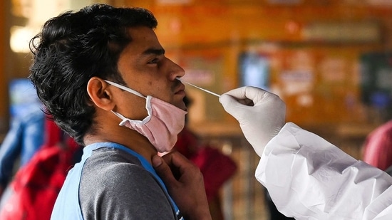 A medical worker takes a swab sample from a passenger for a Rapid Antigen Test (RAT) Covid-19 coronavirus test at the railway station in New Delhi.(AFP) A medical worker takes a swab sample from a passenger for a Rapid Antigen Test (RAT) Covid-19 coronavirus test at the railway station in New Delhi.(AFP)