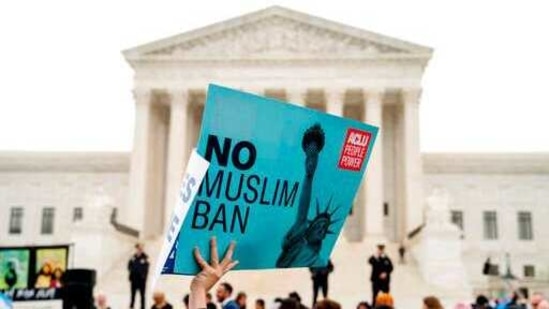 A person holds up a sign that reads "No Muslim Ban" during an anti-Muslim ban rally as the Supreme Court hears arguments.(AP)