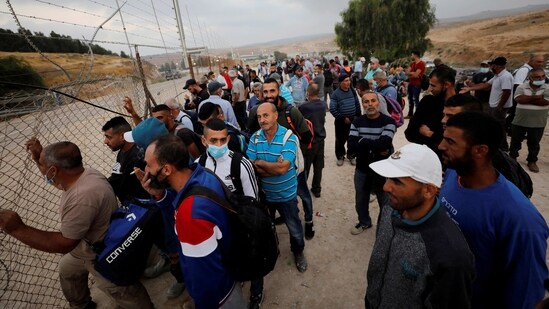 Palestinian labourers gather near an Israeli checkpoint that was closed amid fears of a second wave of Covid-19 infections.(File Photo / REUTERS)