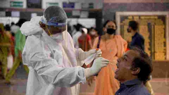 A healthcare worker in a PPE kit collects swab sample of a person at a hospital.(HT File Photo ) A healthcare worker in a PPE kit collects swab sample of a person at a hospital.(HT File Photo )