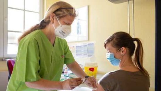 A kindergarten employee receives her Corona vaccination with AstraZeneca's drug from Sylvia Baumbach at the Apolda vaccination center in Apolda, Germany.(AP) A kindergarten employee receives her Corona vaccination with AstraZeneca's drug from Sylvia Baumbach at the Apolda vaccination center in Apolda, Germany.(AP)