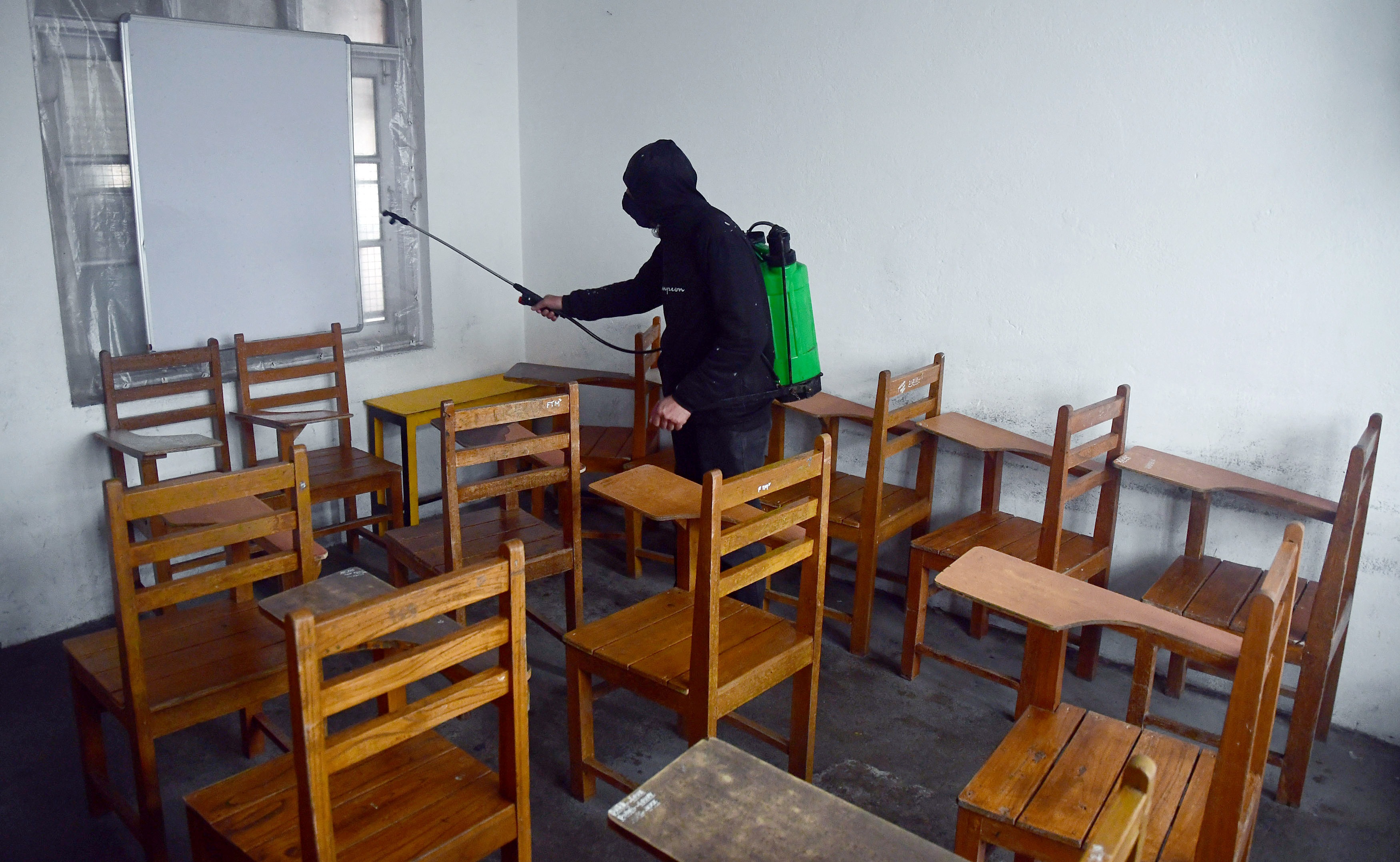 A worker sanitizes the classrooms ahead of the opening of schools after the COVID-19 outbreak, in Srinagar on Saturday. (ANI Photo)