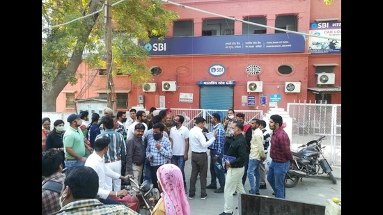 Customers outside the State Bank of India’s branch at Bazaar Number 4 in Abohar on Monday after the building was sealed on the local municipal corporation’s orders for default on paying rent. (HT Photo) Customers outside the State Bank of India’s branch at Bazaar Number 4 in Abohar on Monday after the building was sealed on the local municipal corporation’s orders for default on paying rent. (HT Photo)