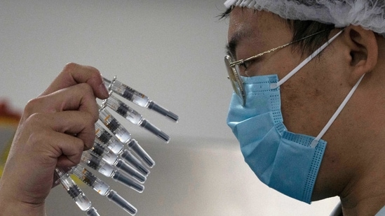 A worker inspects syringes of a vaccine for Covid-19 produced by Sinovac at its factory in Beijing. (AP)