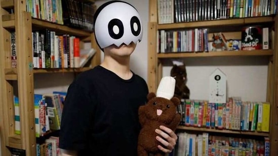 Japanese manga artist Kamentotsu, who goes by his pen name and wears a mask in media appearances, poses for a photograph at his workspace in Tokyo, Japan October 8, 2020. Picture taken October 8, 2020.  (REUTERS)