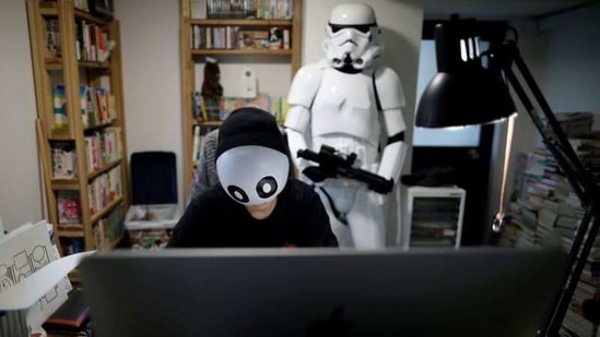 Japanese manga artist Kamentotsu, who goes by his pen name and wears a mask in media appearances, draws his four-panel strip comic 'Koguma's Cake Shop' at his workspace in Tokyo, Japan October 8, 2020. Picture taken October 8, 2020. (REUTERS)