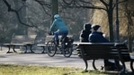 A cyclist drives past people sitting on a park bench at the Volkspark Friedrichshain, amid the coronavirus disease (COVID-19) pandemic, in Berlin, Germany. (REUTERS)