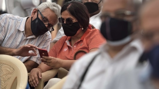 A couple waits to get their first dose of a Covid-19 vaccine, at Bandra Kurla Complex (BKC) in Mumbai on March 1. Some vaccination centres reported issues with the Co-WIN portal used to coordinate the drive and elsewhere people reported confusion while trying to book appointments on a synonymous app that is available on application stores, HT reported.(Satish Bate / HT Photo)