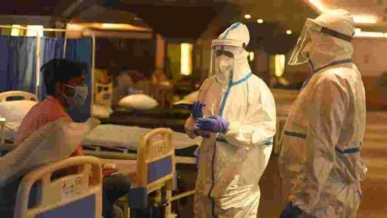 Medical staff in PPE coveralls attend to a person in the temporary Covid-19 care centre attached to LNJP Hospital in New Delhi(Raj K Raj/HT file photo)