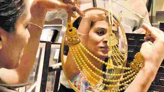 A woman looks at a gold necklace in a shop in Noida in this file photo.(Virendra Singh Gosain/ HT Photo)