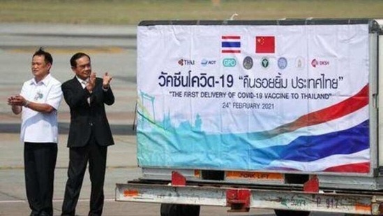 Thailand's Prime Minister Prayuth Chan-ocha and Public Health Minister Anutin Charnvirakul applaud next to a container as they attend the arrival of a plane with a shipment of 200,000 doses of the Sinovac coronavirus disease (COVID-19) vaccine from China at Bangkok's Suvarnabhumi International Airport, Thailand, February 24, 2021.(Reuters)