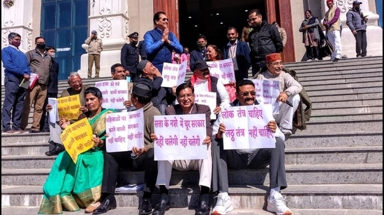 Congress MLAs stage a sit-in at the entrance of the House in Gharsain on Wednesday, March 3. Speaker Premchand Agarwal stands with folded hands) . (Kalyan Das/HT photo) Congress MLAs stage a sit-in at the entrance of the House in Gharsain on Wednesday, March 3. Speaker Premchand Agarwal stands with folded hands) . (Kalyan Das/HT photo)